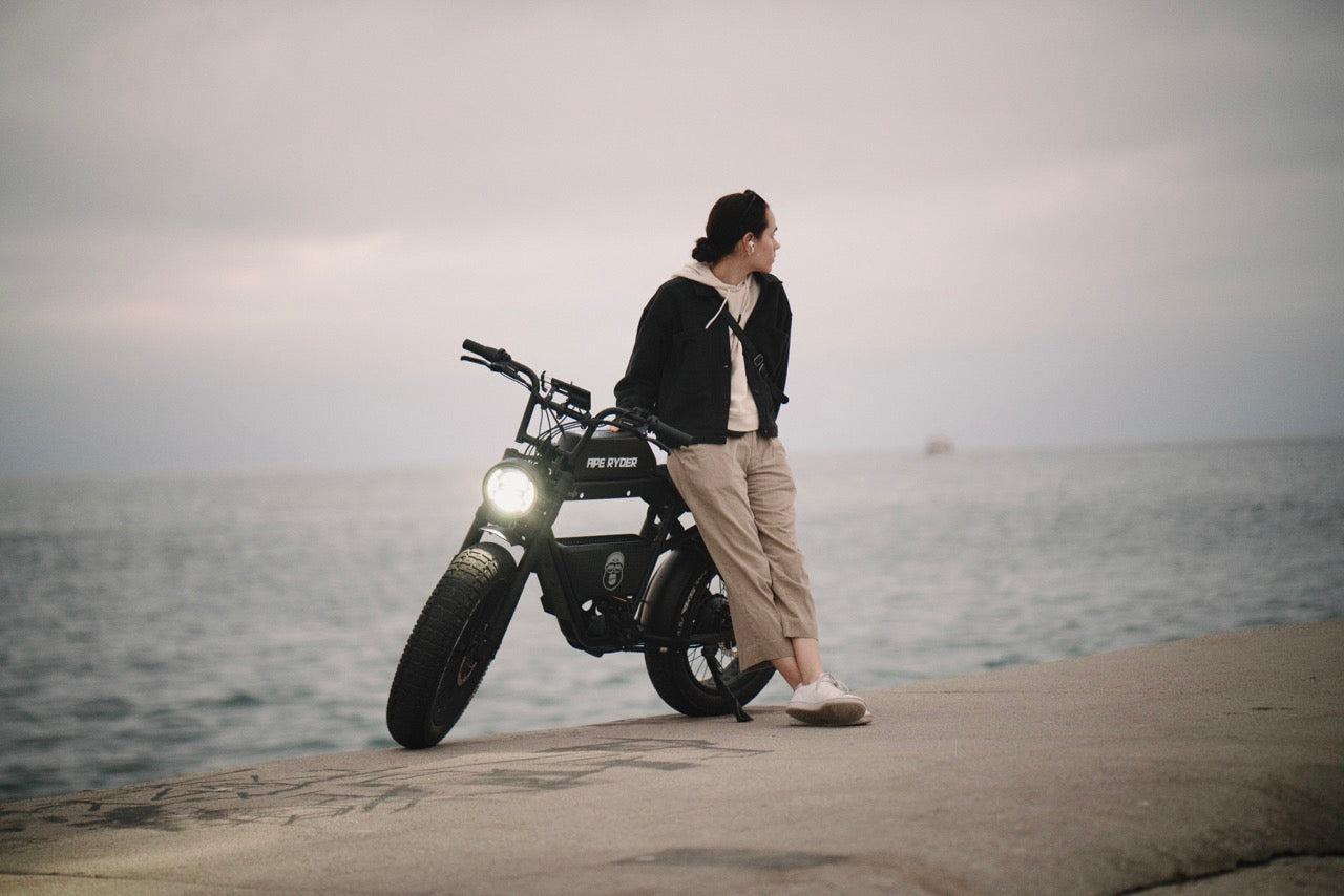 woman with e-bike near ocean
