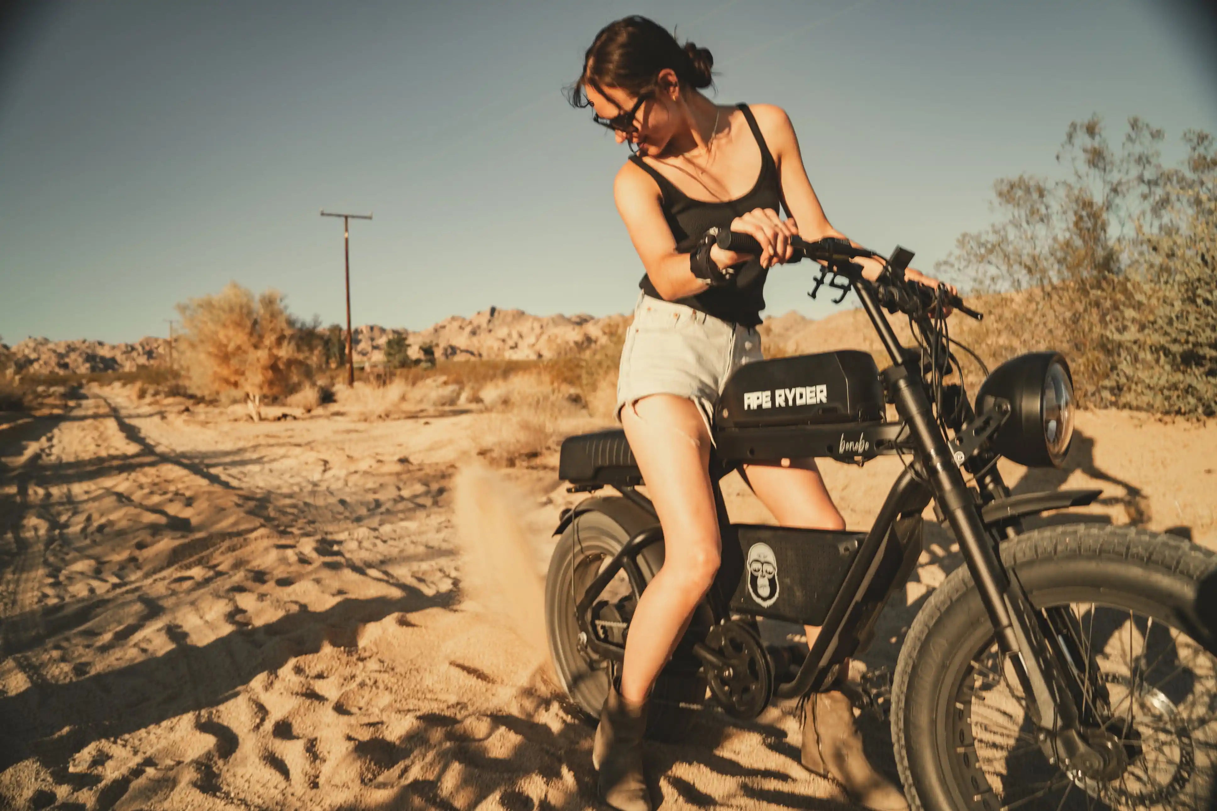 a girl with her ape ryder e-bike in desert