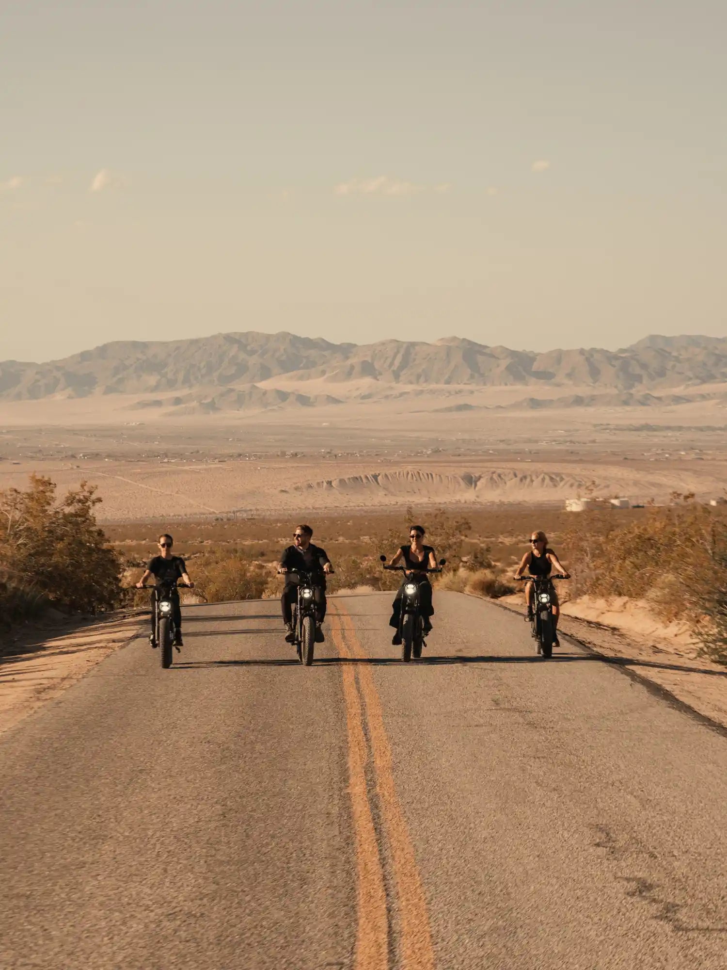 four friends riding their ape ryder e-bikes on the road