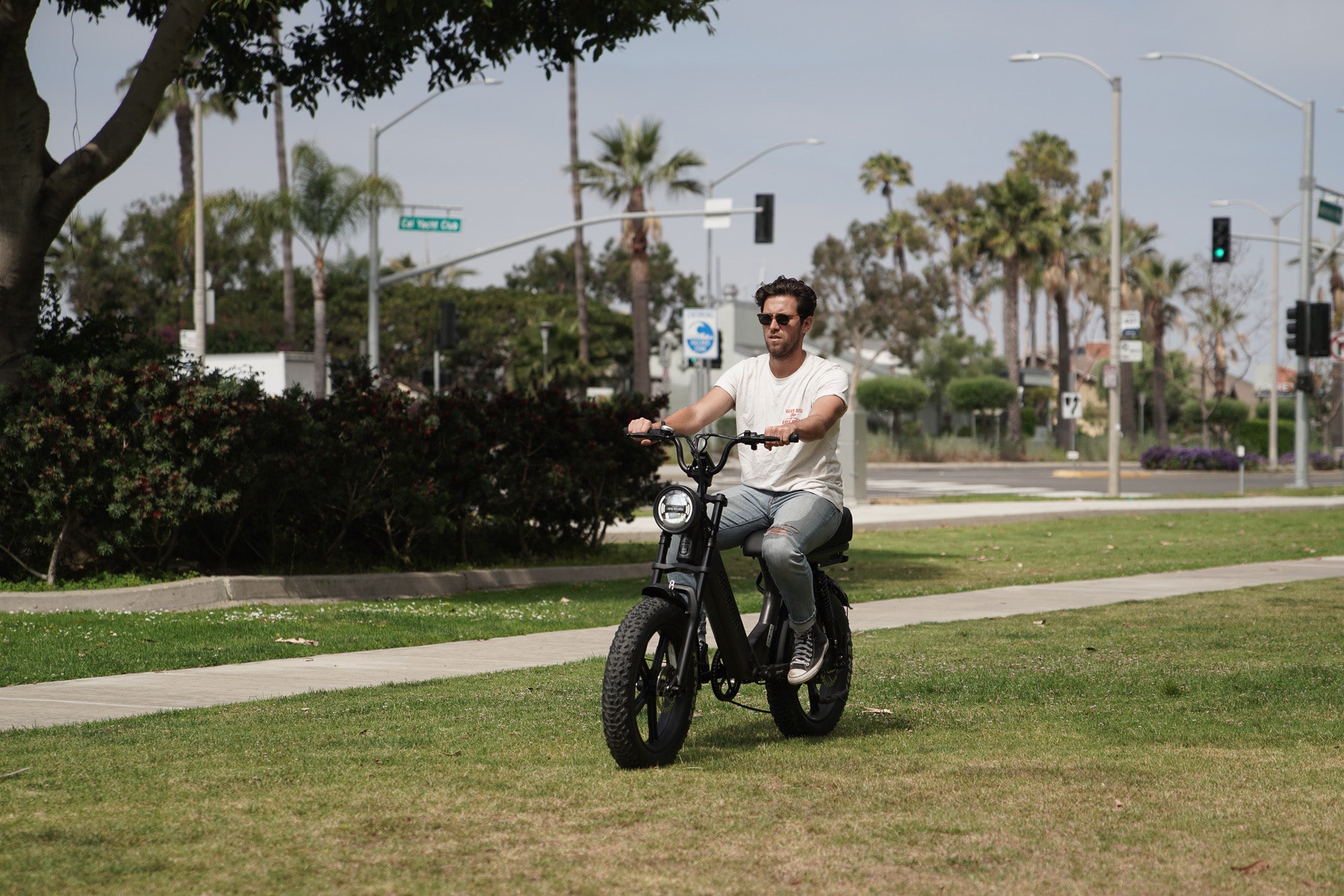 Young guy riding black ebike on grass