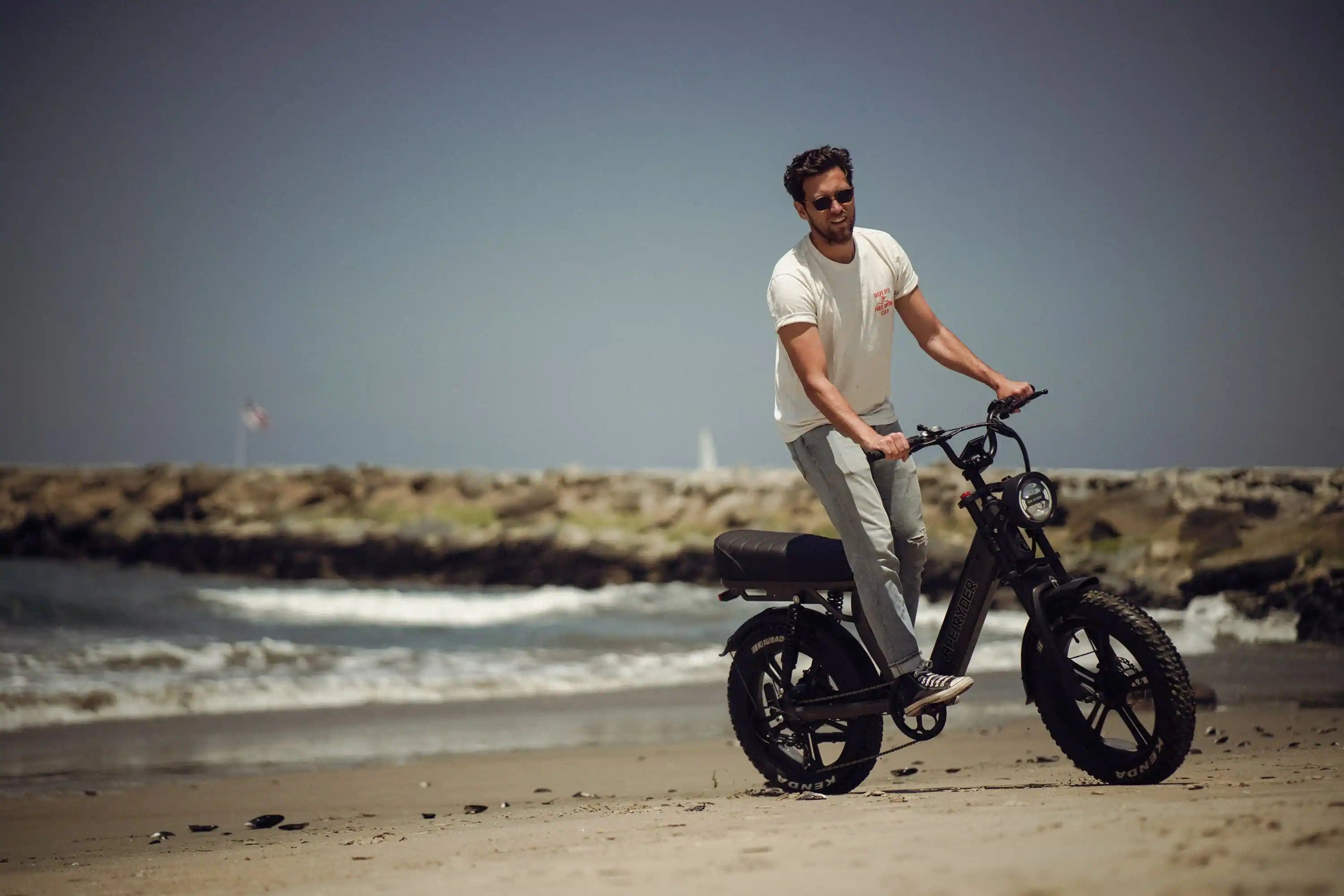 man riding in his ape ryder electric bike in beach