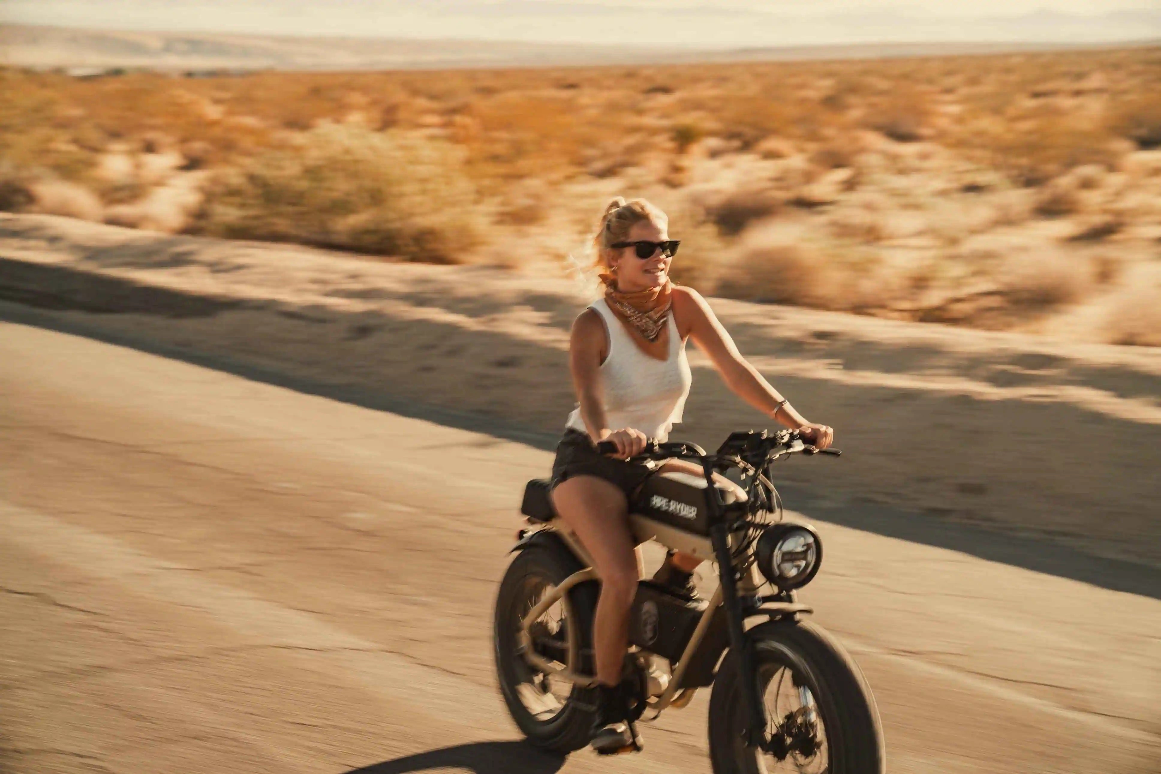 blonde girl riding e-bike on the road