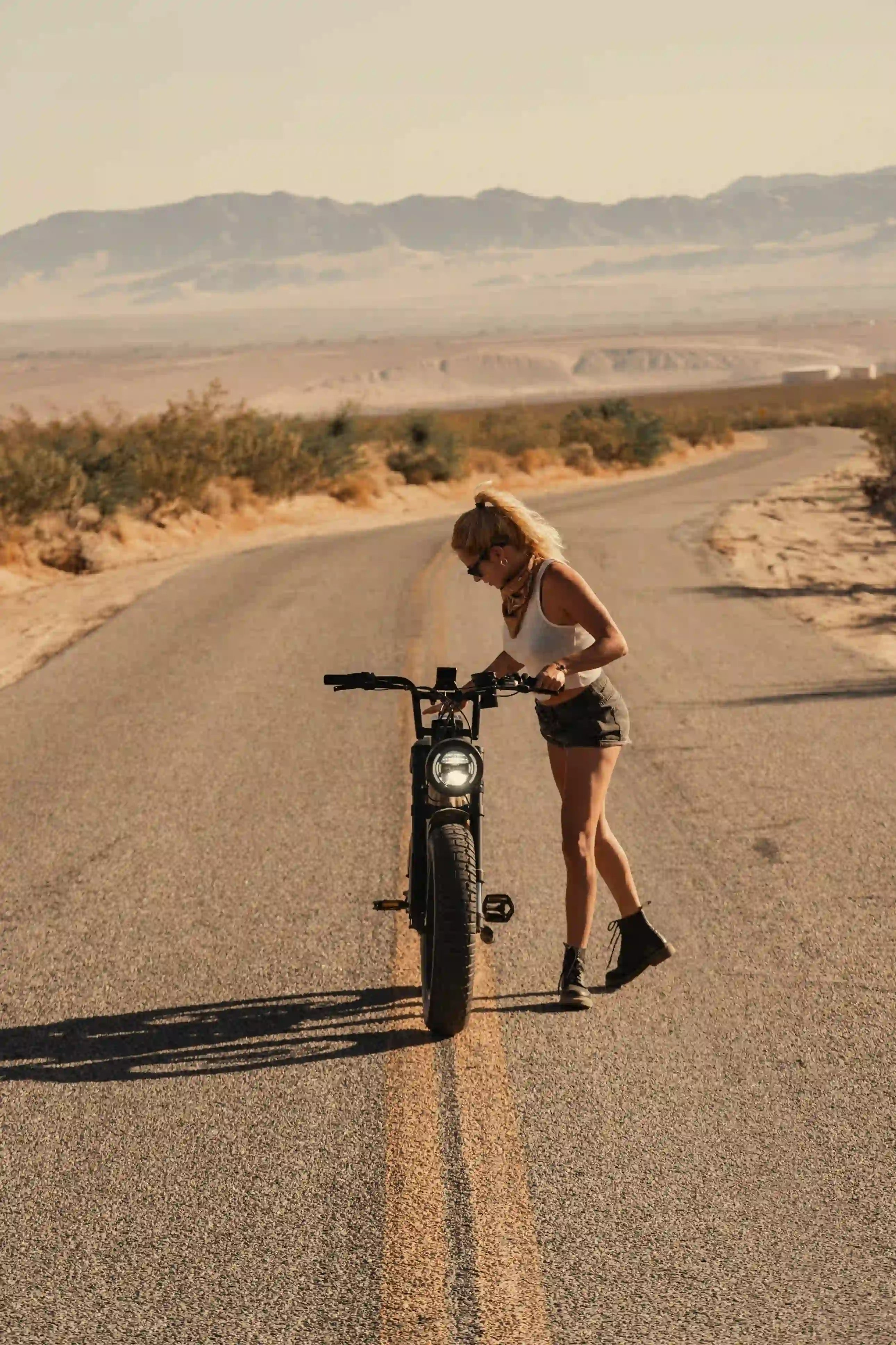 girl standing next to her e-bike on the road